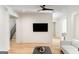 A bright, open-concept living room featuring hardwood floors, a flat-screen TV, and a modern ceiling fan at 490 Mount Paran Rd, Atlanta, GA 30327