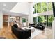 Open-concept living room with hardwood floors, kitchen access, fireplace, and deck access at 490 Mount Paran Rd, Atlanta, GA 30327