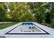 An outdoor retreat featuring a modern pool, sunken lounge area, and stepping stones amidst serene, lush landscaping at 490 Mount Paran Rd, Atlanta, GA 30327