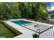 A luxurious pool with a built-in lounge area, surrounded by lush greenery and a sleek, modern design at 490 Mount Paran Rd, Atlanta, GA 30327