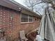 Brick home exterior featuring windows and covered patio area with weathered outdoor furniture at 2234 Glendale Dr, Decatur, GA 30032