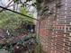 Exterior side of a brick home with a chain link fence overgrown with vines at 2234 Glendale Dr, Decatur, GA 30032