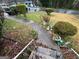 Steps leading down to a front yard with overgrown plants and wet leaves at 2234 Glendale Dr, Decatur, GA 30032