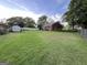 Spacious backyard with lush green grass and a white storage shed, surrounded by mature trees at 359 Keys Ferry St, Mcdonough, GA 30253
