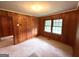 Cozy bedroom with wood paneling, carpeted floors, and large windows offering plenty of natural light at 359 Keys Ferry St, Mcdonough, GA 30253