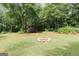 Secluded backyard features a storage shed surrounded by lush foliage and a fire pit at 134 Ashwood Dr, Waco, GA 30182
