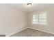 A well-lit bedroom featuring neutral walls, plush carpeting, and a window with bright sunlight at 134 Ashwood Dr, Waco, GA 30182