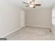 Bright bedroom features neutral walls, plush carpeting, and a ceiling fan for added comfort at 134 Ashwood Dr, Waco, GA 30182