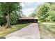 A charming single story home with a covered porch and long driveway surrounded by lush trees at 134 Ashwood Dr, Waco, GA 30182