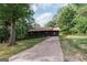 A charming single story home with a covered porch and long driveway surrounded by lush trees at 134 Ashwood Dr, Waco, GA 30182