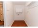 Spacious laundry room with overhead storage, washer and dryer hookups, and hardwood flooring at 134 Ashwood Dr, Waco, GA 30182
