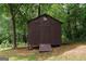 Outdoor shed is constructed of wood and set on a raised foundation in a wooded backyard at 134 Ashwood Dr, Waco, GA 30182