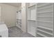 Walk-in closet with carpet flooring and white shelving and drawers at 5768 Grande River Rd, Atlanta, GA 30349