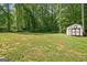 Large backyard featuring a shed and mature tree line at 180 E Ranchette Rd, Temple, GA 30179