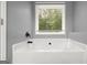 Bright bathroom featuring a modern soaking tub and large window with a wooded view at 180 E Ranchette Rd, Temple, GA 30179
