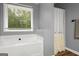 Bright bathroom with a modern soaking tub and a view of wooded scenery from the window at 180 E Ranchette Rd, Temple, GA 30179