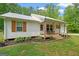 Charming white home with a cozy front porch, rocking chairs, and beautiful landscaping at 180 E Ranchette Rd, Temple, GA 30179