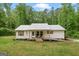 Quaint one-story home with a metal roof, wooden shutters, and a welcoming front porch at 180 E Ranchette Rd, Temple, GA 30179