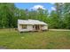 Cozy home nestled in a wooded area, featuring a metal roof and charming front porch at 180 E Ranchette Rd, Temple, GA 30179