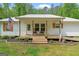 Inviting home featuring a covered front porch with rocking chairs and wood accents at 180 E Ranchette Rd, Temple, GA 30179