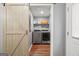 Laundry room with sliding barn door, washer, dryer, and storage shelving at 180 E Ranchette Rd, Temple, GA 30179