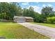A single-story brick home with an attached garage, surrounded by a green lawn and tall trees at 295 Merrydale Dr, Fayetteville, GA 30215