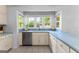 Bright kitchen featuring stainless steel dishwasher and sink, with white cabinetry and tile flooring at 295 Merrydale Dr, Fayetteville, GA 30215