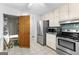 Kitchen with stainless steel appliances, white cabinets, and tiled floors at 295 Merrydale Dr, Fayetteville, GA 30215