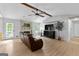 Living room with light hardwood floors, ceiling fan, brick fireplace, and comfortable leather seating at 295 Merrydale Dr, Fayetteville, GA 30215