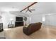 Living room with light wood flooring, ceiling fan, brick fireplace, and comfortable leather couch at 295 Merrydale Dr, Fayetteville, GA 30215