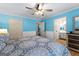 Well-lit bedroom with blue walls, a ceiling fan, and access to an en-suite bathroom, offering convenience and style at 295 Merrydale Dr, Fayetteville, GA 30215