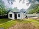 Charming white exterior with black trim, complemented by a well-maintained lawn and mature trees at 2502 Barge Sw Rd, Atlanta, GA 30331