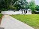 Charming home featuring a well-maintained lawn, complemented by a white picket fence for added curb appeal at 2502 Barge Sw Rd, Atlanta, GA 30331