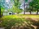 Large backyard with ample green space, mature trees, and a white privacy fence at 2502 Barge Sw Rd, Atlanta, GA 30331