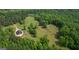 Aerial shot of the wooded property featuring a modern home, grassy fields, and natural beauty at 9511 High Point Rd, Villa Rica, GA 30180