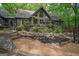 View of backyard with deck, stone steps, and a rock water feature with lush garden area at 9511 High Point Rd, Villa Rica, GA 30180