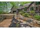 Backyard with rock water feature and steps leading to outdoor kitchen and upper deck at 9511 High Point Rd, Villa Rica, GA 30180