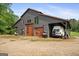 Modern barn with wood paneled doors, covered parking, and vehicle storage, offering versatile functionality at 9511 High Point Rd, Villa Rica, GA 30180