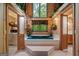 Luxurious bathroom featuring a jetted tub with tile surround and scenic wooded views at 9511 High Point Rd, Villa Rica, GA 30180