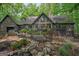 Exterior of home with rock water feature, iron bridge, and large deck in lush backyard at 9511 High Point Rd, Villa Rica, GA 30180