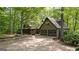 Exterior showing a three car garage and driveway of home nestled among mature trees and landscaping at 9511 High Point Rd, Villa Rica, GA 30180