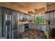Rustic kitchen features stainless steel appliances, warm tile floors, and wood-beam ceiling at 9511 High Point Rd, Villa Rica, GA 30180