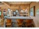 Kitchen bar seating with granite counters overlooks rustic kitchen with stainless appliances and wood ceiling at 9511 High Point Rd, Villa Rica, GA 30180