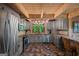 Rustic kitchen features stainless steel appliances, warm tile floors, and wood-beam ceiling at 9511 High Point Rd, Villa Rica, GA 30180