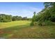 Expansive green field surrounded by trees, and split rail fence showing property line at 9511 High Point Rd, Villa Rica, GA 30180