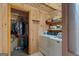 Charming laundry room features wood paneling, washer, dryer, closet, and shelving at 9511 High Point Rd, Villa Rica, GA 30180