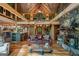Open-concept living room with exposed beams, stone fireplace, and a view to the adjoining kitchen at 9511 High Point Rd, Villa Rica, GA 30180