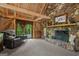 Cozy living room with stone fireplace, wood-beamed ceilings, and walkout to private balcony at 9511 High Point Rd, Villa Rica, GA 30180