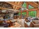 Bright open living room with stone fireplace, vaulted wood ceilings, and large windows overlooking wooded property at 9511 High Point Rd, Villa Rica, GA 30180