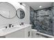 Modern bathroom with blue-grey tiled shower, double vanity, and sleek black fixtures at 1153 Dawn View Nw Ln, Atlanta, GA 30327